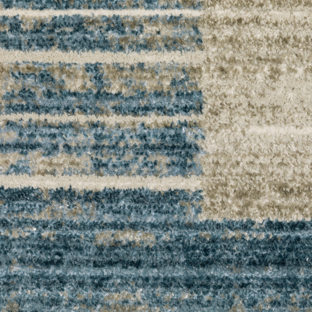 6' X 9' Blue Dark Blue Teal Grey Ivory Beige And Tan Geometric Power Loom Stain Resistant Area Rug With Fringe