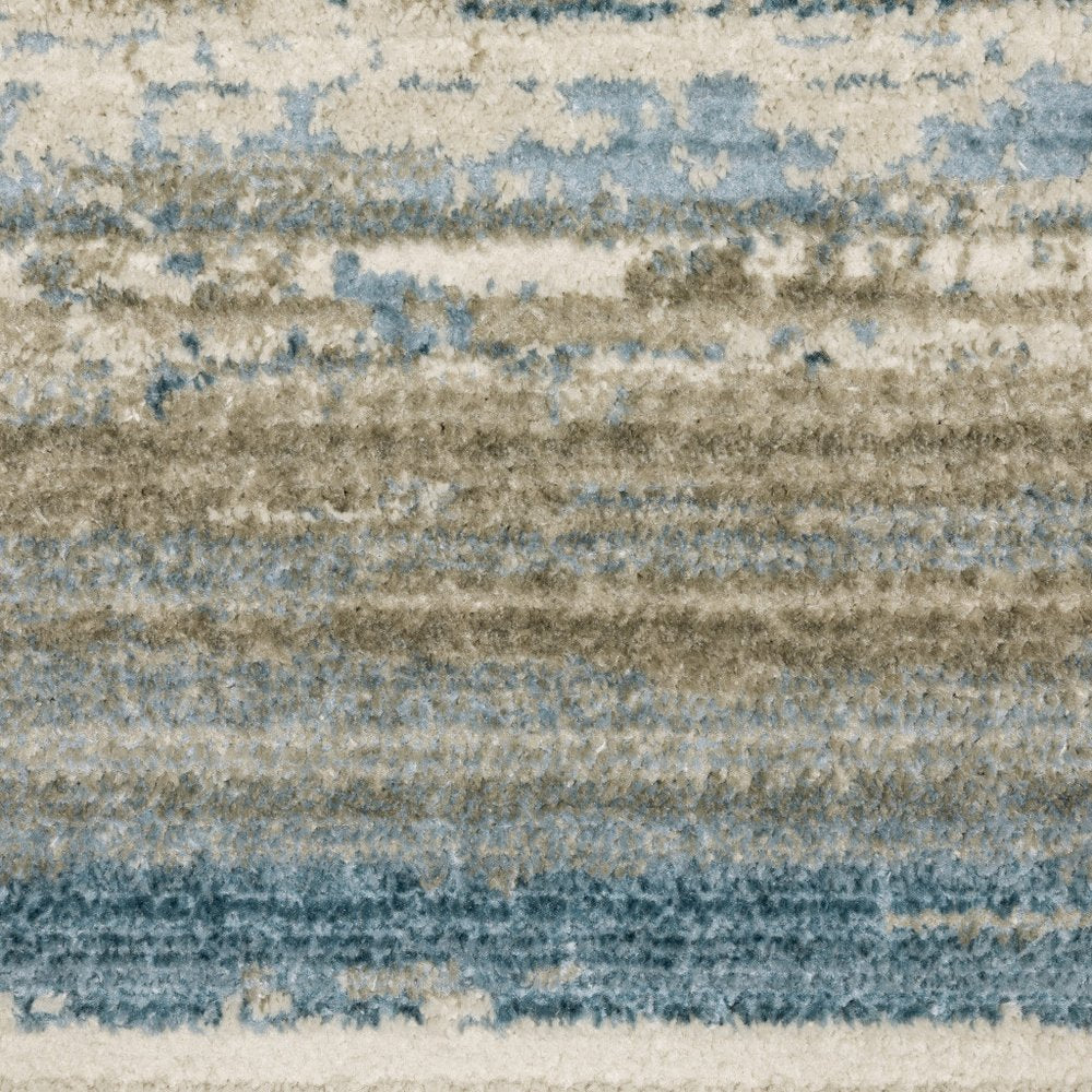 8' X 11' Ivory Beige Grey Blue And Tan Abstract Power Loom Stain Resistant Area Rug With Fringe