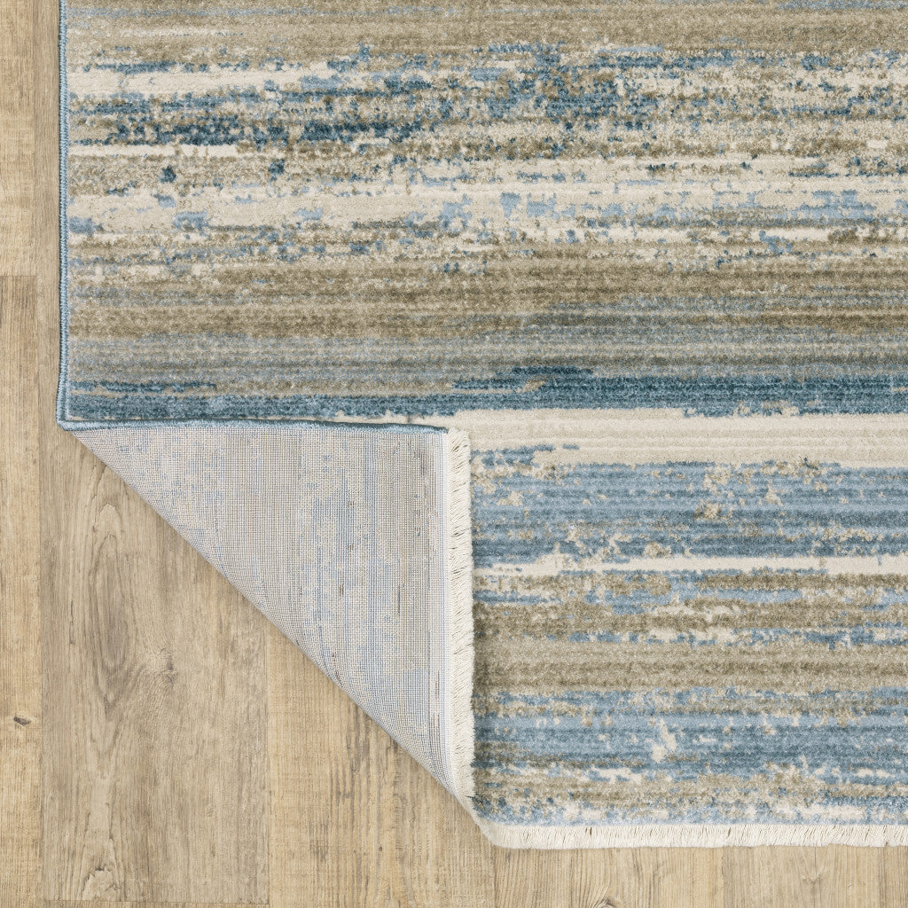 8' X 11' Ivory Beige Grey Blue And Tan Abstract Power Loom Stain Resistant Area Rug With Fringe